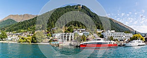 Close up boats on the Marina and Hillside houses in Queenstown Otago New Zealand rising from the shore of Lake Wakatipu