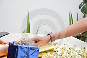 Close up of body part female hand preparing a gift at the table