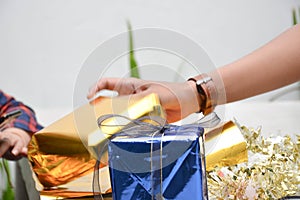 Close up of body part female hand preparing a gift at the table