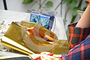 Close up of body part female hand preparing a gift at the table