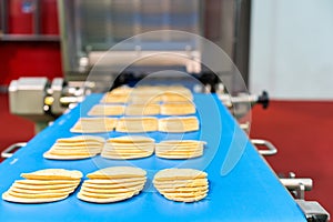 Close up bologna sliced plate on conveyor of automatic slicer machine for industrial food manufacture