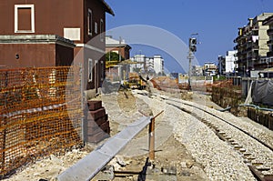 Close up bolted butt of rails and wooden sleepers laid on groundwork crushed stone.