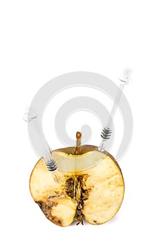 Close up Boring trace of a codling moth Cydia Pomonella, in a half wormy apple. On white background. With syringe. Concept non org