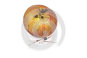 Close up Boring trace of a codling moth Cydia Pomonella, in a wormy apple. On white background. With syringe. Concept non organic photo