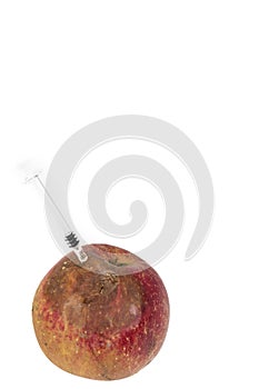 Close up Boring trace of a codling moth Cydia Pomonella, in a wormy apple. On white background. With syringe. Concept non organic photo