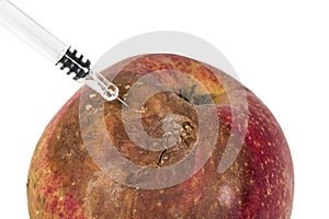 Close up Boring trace of a codling moth Cydia Pomonella, in a wormy apple. On white background. With syringe. Concept non organic photo