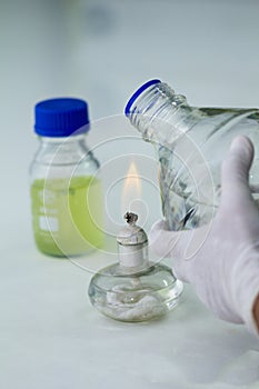 Close-up of bottle being sterilized with an alcohol burner before use in marine plankton culture in Scientific laboratory