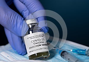 Close up of bottle of new Covid-19 vaccine for Omicron variant wtih gloved hand