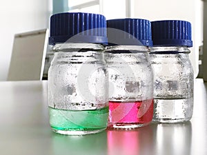 Close up Bottles and blue cap with green, red and clear solution buffer pH 4, 7 and 10 for analysis and calibrate the pH meter.