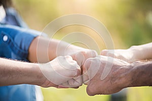 Close up bottom view of people giving fist bump showing unity and teamwork. Friendship happiness leisure partnership team concept