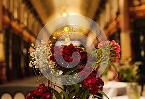 Close up of a bouquet of vibrant red flowers preceding & x27;Leadenhall market& x27;, in the centre of London, UK.