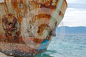 Close-up at the bow with anchors of corroded and abandoned shipwreck washed ashore.