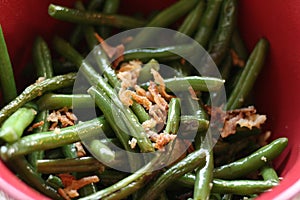 Close up bowl of cooked green beans with onion