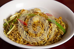 Close-up of bowl of rice curry noodles. Typical oriental dish. Isolated image