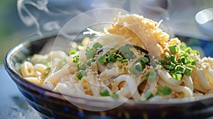 A close up of a bowl of steaming hot udon noodles adorned with scallions and tempura flakes at a Japanese food festival