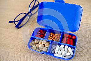 Close-up of a box for medical pills with a package of pills for daily medication with white, yellow drugs and capsules