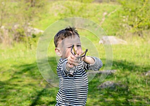 Close Up of Boy Holding Drawn Back Sling Shot