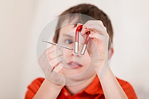 Close up on boy playing with nail and magnet photo