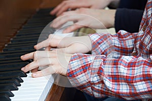 Close Up Of Boy Playing Piano Duet With Teacher