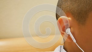 Close up of boy`s ear using earphone.