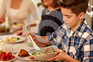 Close up of boy with salad at family dinner party