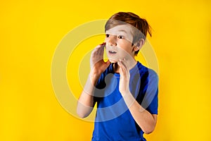 Close up of a boy screaming to someone. A 9-year-old boy invite for a holiday, a stock, a sale. Photo of a boy on an