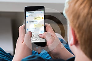 Boy Typing Text Message On Mobile Phone photo