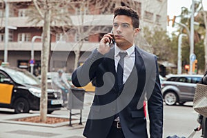 Close up of boy walking with blue suit and calling by phone in city