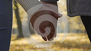 Close-up of boyfriend and girlfriend clasping each other hands in slow-motion