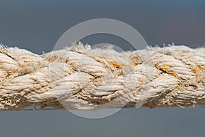 Close up on the braided strands of a rope on grey