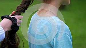 Close up braiding plait two little girls do hairstyles outdoors