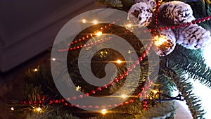 Close-up of branch of Christmas tree with garland. Frame. Branches of Christmas tree are decorated with garland, beads