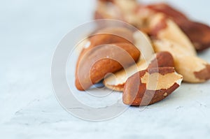 Close up of brasil nuts in a wooden plate on white background. C