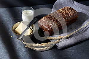 close up of bread, butter, knife and glass of milk