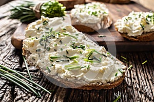 Close-up of bread slice with traditional Slovak bryndza spread made of sheep cheese with freshly cut chives placed on