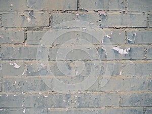 Close up of brick wall with gray green chipped paint.