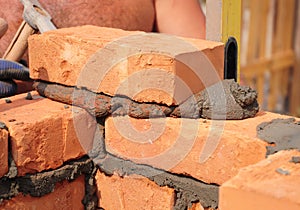 Close up on bricklayer hands laying bricks.