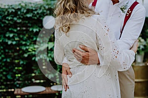 Close-up of bride and groom dancing at their outdoor wedding party.