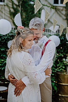 Close-up of bride and groom dancing at their outdoor wedding party.