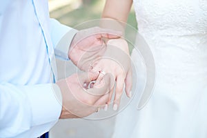 Close-up bride and groom`s hands with wedding rings