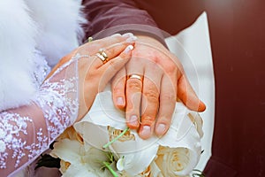 Close-up Bride and grooms hands with wedding rings golden ring on finger.