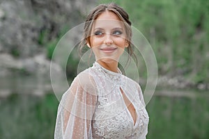 close up. The bride in a white dress on the bank of a mountain river.
