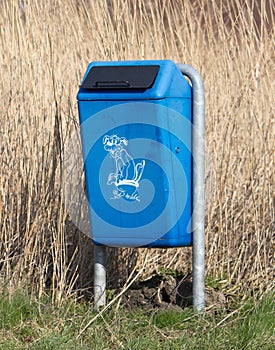 Close up of bright blue dog mess poop bin