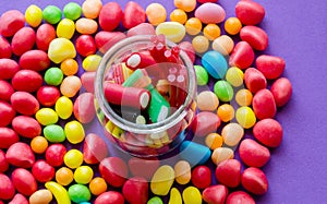 Close-up of bright candies and jar with liquorice