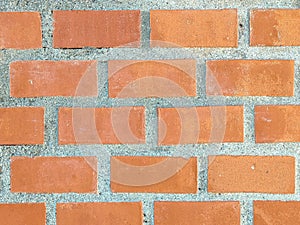 Close-up of a bright orange brick wall, featuring a textured surface with various shades of orange