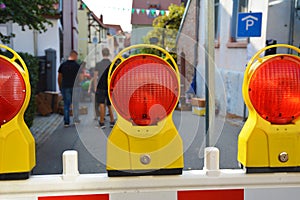 Close up of bright red reflector warning light attached to yellow scaffold at road rerouting