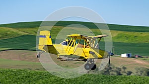 Close up of a bright yellow crop duster over the Palouse