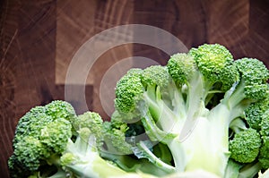 Close-up broccoli inflorescences on wooden blurred background with copy space. Top view. Selectiv focus. Fresh head of broccoli