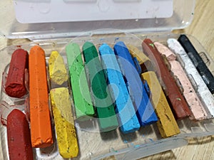 A close up of broken crayons of various colours