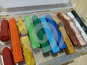 A close up of broken crayons of various colours